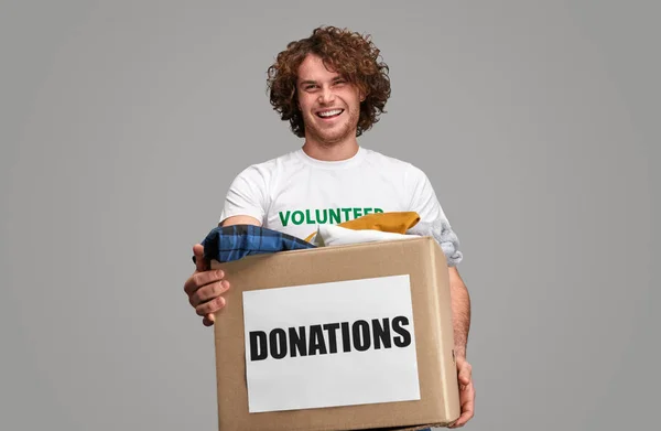 Smiling volunteer with donations box — Stock Photo, Image