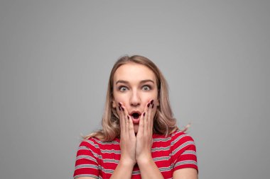 Genç bir kadın şok içinde kameraya bakıyor.