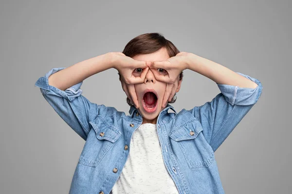 Förvånad pojke gör hand mask gest — Stockfoto