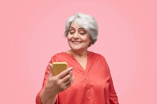 Sonriente anciana usando teléfono inteligente — Foto de Stock