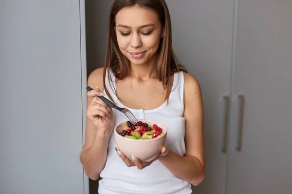 Giovane donna che mangia porridge con frutta — Foto Stock