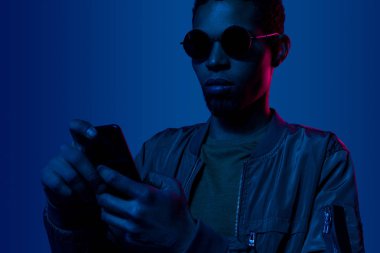 Geceleri cep telefonu kullanan Afrikalı genç bir adam.