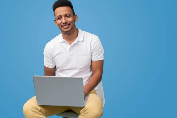 Ethnic male smiling and using laptop — Stock Photo, Image