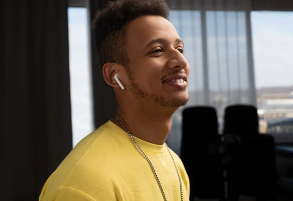 Chico negro alegre escuchando música en la habitación moderna — Foto de Stock