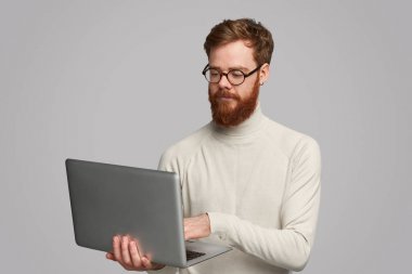 Dizüstü bilgisayar kullanarak odaklanmış yakışıklı adam