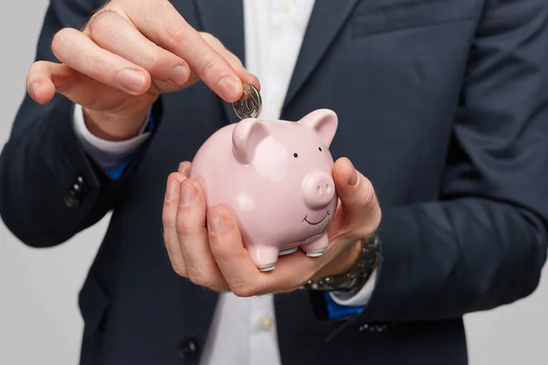 Gewas zakenman putting munt binnen Piggy Bank — Stockfoto