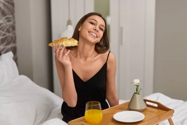 Mujer alegre desayunando romántico en la cama — Foto de Stock