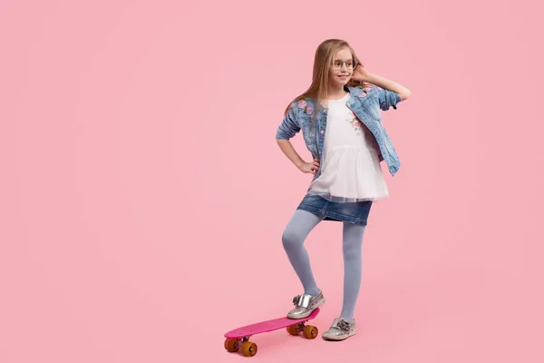 Stylisches Kind posiert in der Nähe von Longboard — Stockfoto