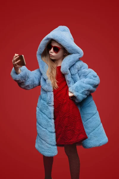 Menina na moda em casaco de pele tomando selfie — Fotografia de Stock