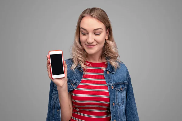 Mujer sonriente mirando el teléfono inteligente durante la presentación — Foto de Stock