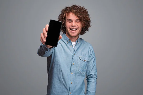 Chico alegre mostrando teléfono inteligente —  Fotos de Stock