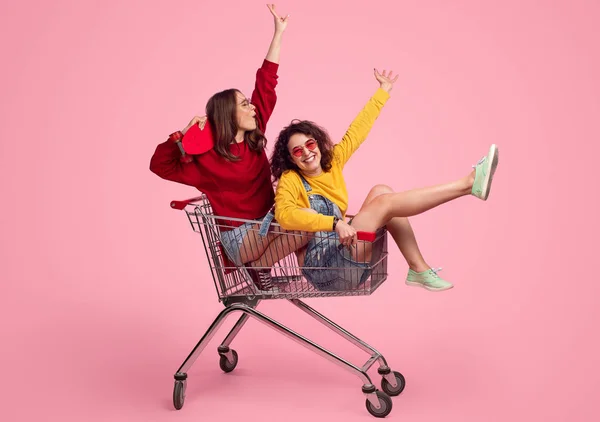 Young hipsters riding shopping cart — Stock Photo, Image