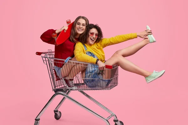 Hipsters alegres montando carrinho de compras — Fotografia de Stock
