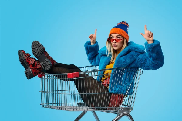 Mulher estranha no carrinho de compras apontando para cima — Fotografia de Stock