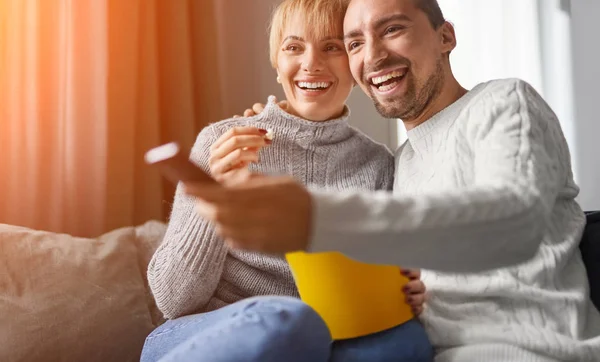 Cheerful couple eating popcorn and watching TV — Stock Photo, Image