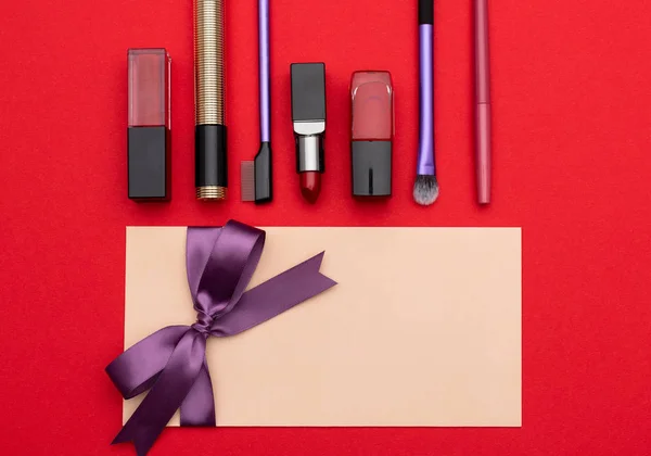 Set of decorative cosmetics near gift coupon — Stock Photo, Image
