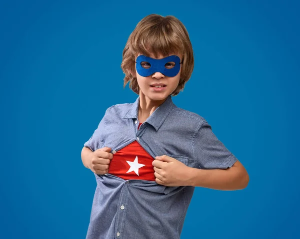 Впевнений хлопчик показує супергеройську емблему — стокове фото