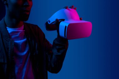 Crop black man showing VR headset clipart