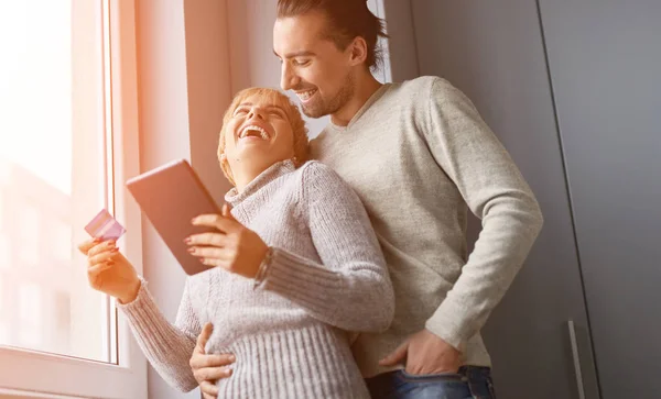 Happy couple shopping online near window — Stock Photo, Image