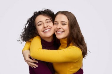 Best friends hugging and cheerfully smiling clipart