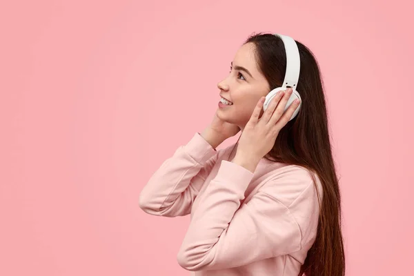 Adolescente sonriente escuchando música y mirando el espacio vacío —  Fotos de Stock