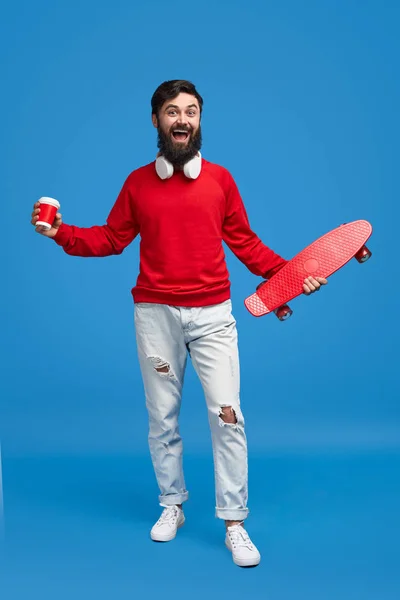 Glad hipster med dryck och skateboard — Stockfoto