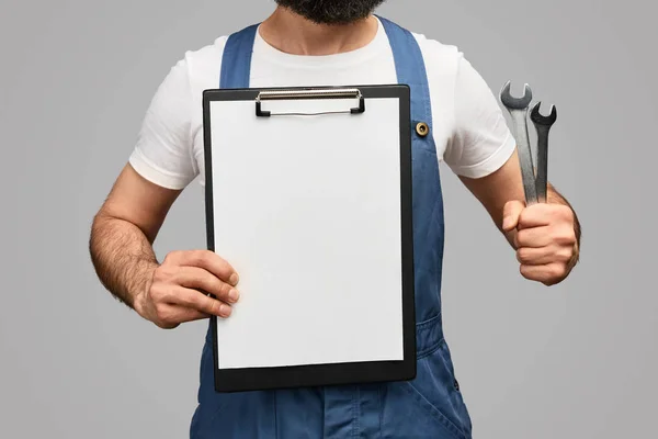 Crop technician with clipboard and wrenches — Stock Photo, Image