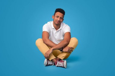 Rahat siyah adam çapraz bacaklar ile oturan