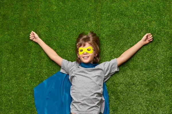 Glad superhjälte koppla av på gräs — Stockfoto