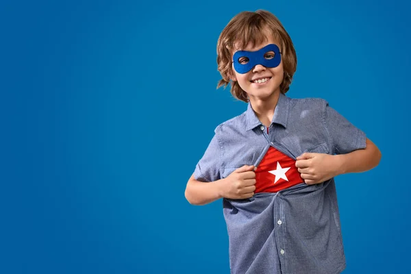 Fröhlicher Junge zeigt Superheldenkostüm — Stockfoto