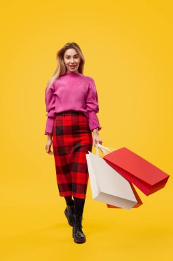 Woman with shopping bags walking towards camera