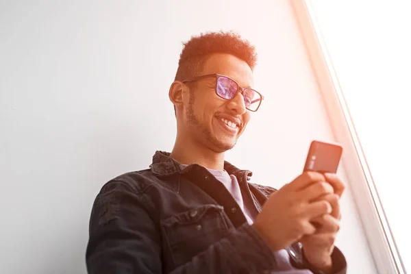 Cheerful black male using smartphone in morning — Stock Photo, Image