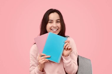 Not defterlerini gösteren genç öğrenci
