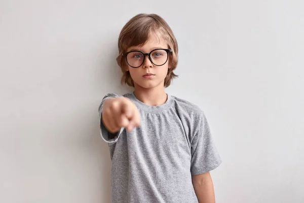 Serious schoolboy pointing at camera — Stock Photo, Image