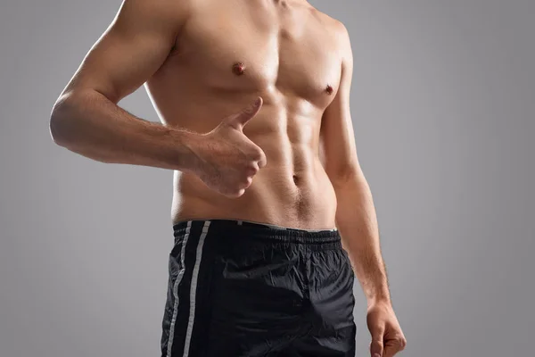 Crop shirtless bodybuilder showing thumb up — Stock Photo, Image