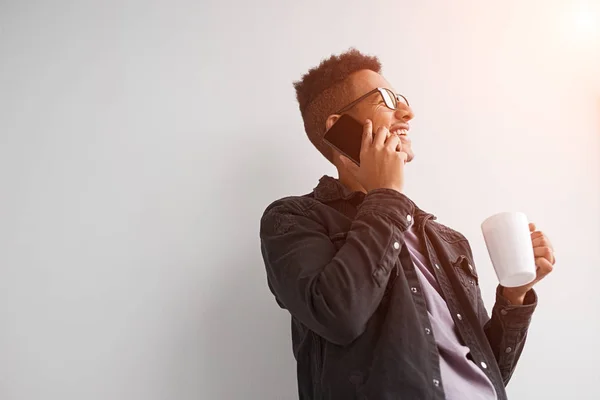 Homem preto com copo falando no telefone sob flare — Fotografia de Stock