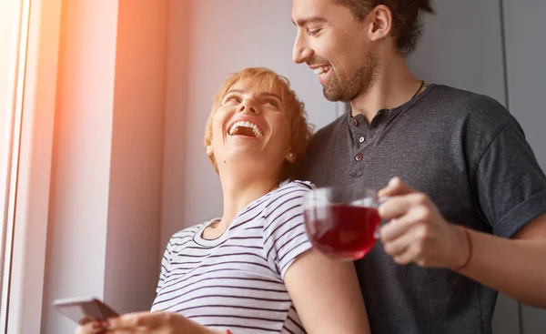 Loving couple laughing near window in morning — Stock Photo, Image