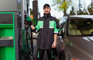 Dispenser ile gülümseyen dolum istasyonu çalışanı