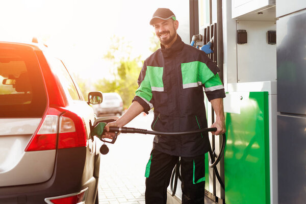 Smiling worker refueling car