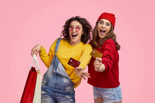 Amigos alegres com cartões de crédito durante as compras — Fotografia de Stock