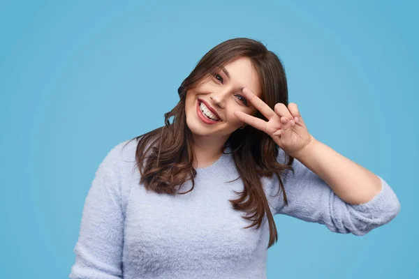 Kaygısız tombul kadın gesturing V işareti — Stok fotoğraf