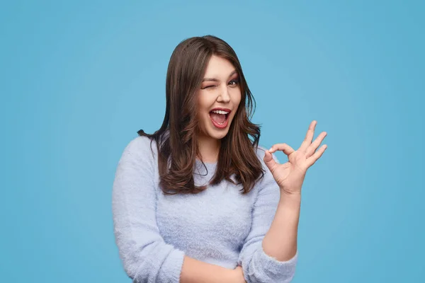 Cheerful plump woman winking and gesturing OK — Stock Photo, Image