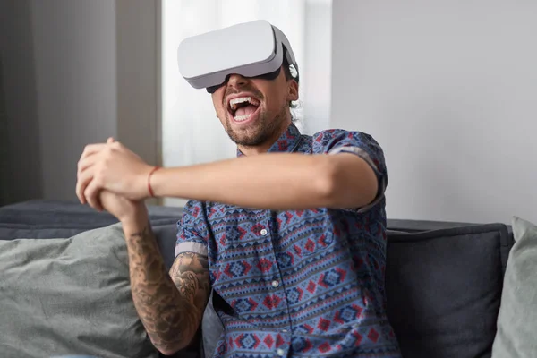 Homem animado jogando jogo VR no sofá — Fotografia de Stock