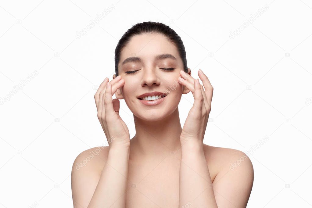 Smiling woman smearing cream on face