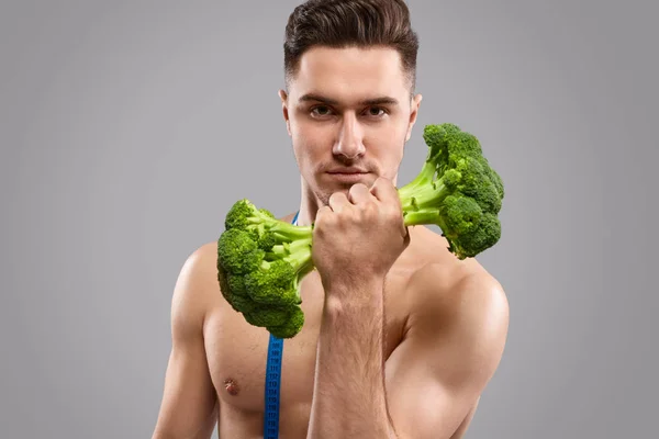 Shirtless athlete exercising with broccoli dumbbell — Stock Photo, Image