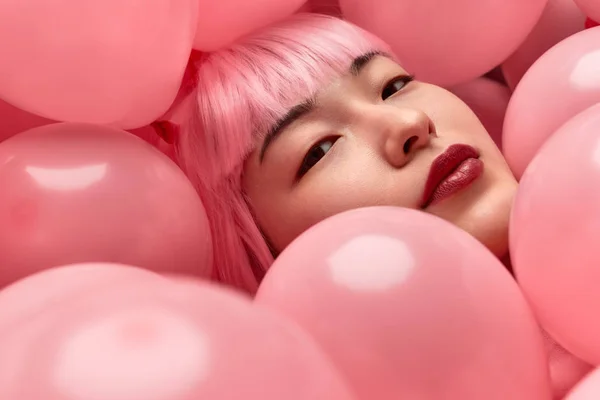 Atrakcyjna Azjatycka Kobieta w różowej peruce pod balonami — Zdjęcie stockowe