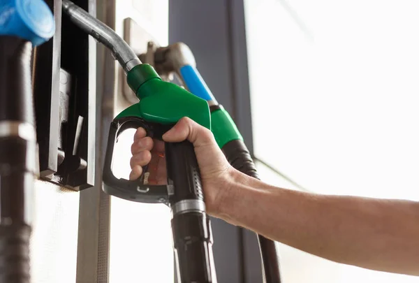 Cosecha mano tomando dispensador de combustible verde —  Fotos de Stock