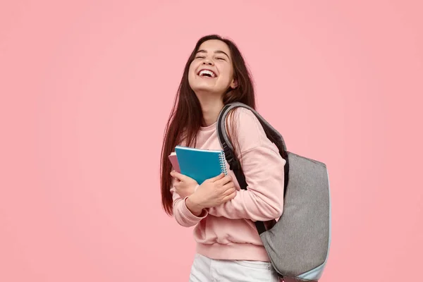 Estudante animado rindo e abraçando cadernos — Fotografia de Stock