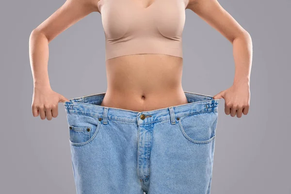 Cortar senhora magro em jeans de grandes dimensões — Fotografia de Stock