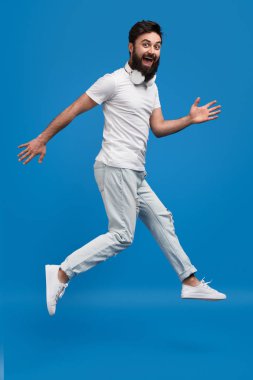 Neşeli hipster atlama ve kameraya bakarak